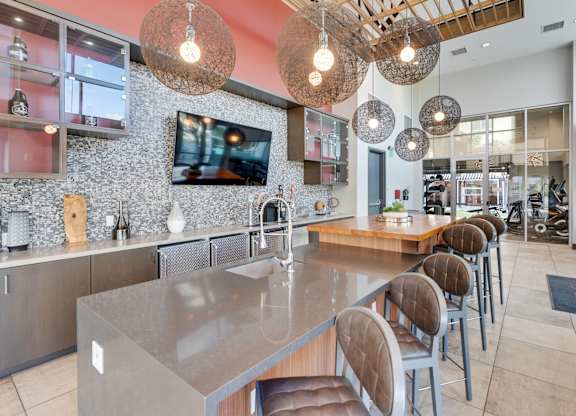 A modern kitchen with a long island and chairs.