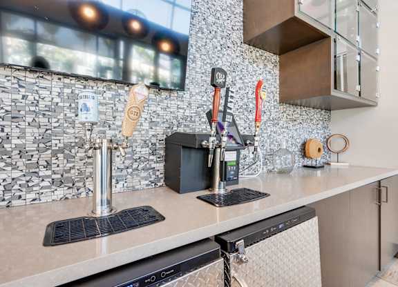 A kitchen with a black and white tiled backsplash and a black dishwasher.