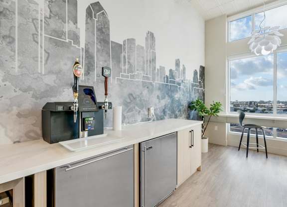A modern kitchen with a cityscape mural on the wall.