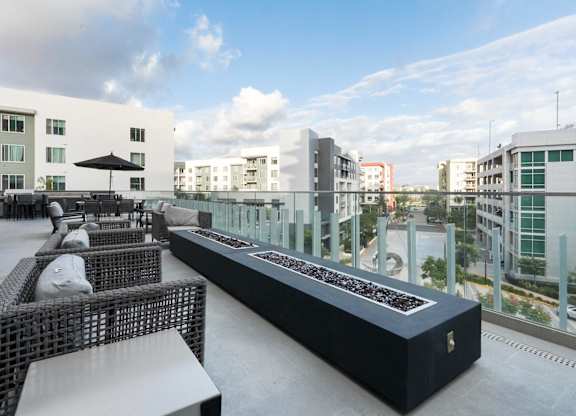 A black and white outdoor seating area with a long table and chairs.