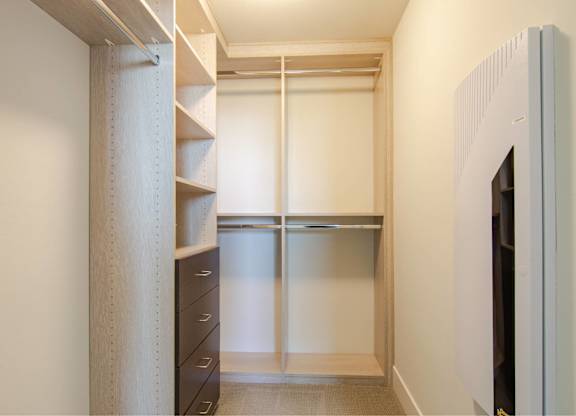 A white closet with a sliding door and a shelf.