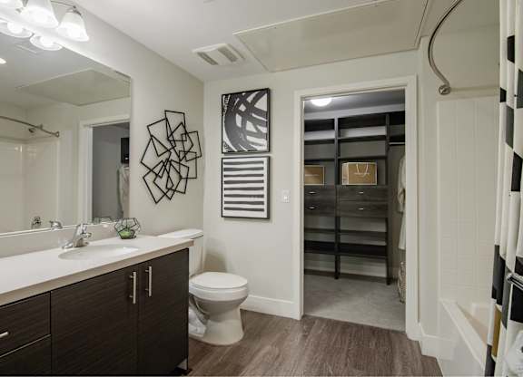 A bathroom with a toilet, sink, and a mirror.