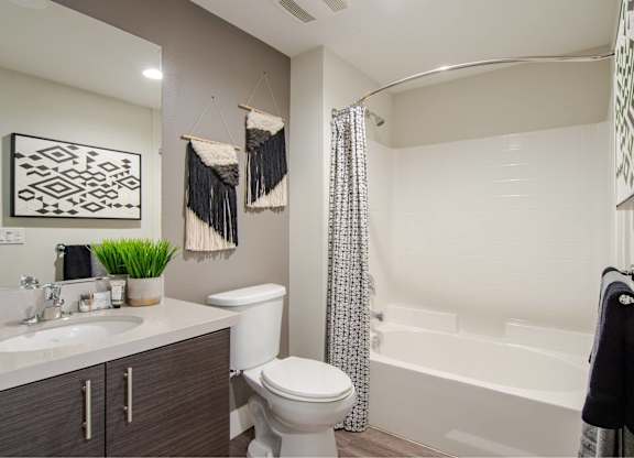 A bathroom with a white toilet, a white sink, and a white bathtub.