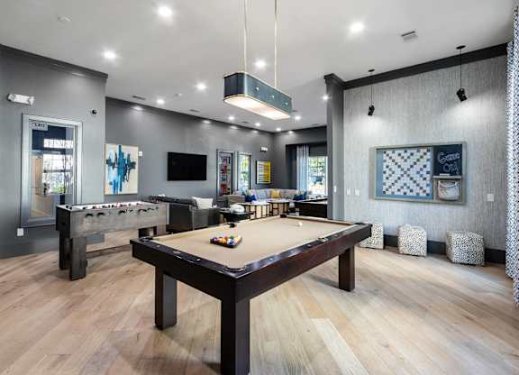A room with a pool table and a TV.