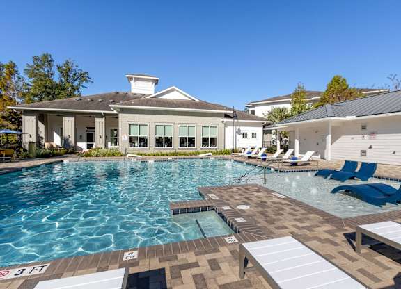 A large swimming pool with a building in the background.