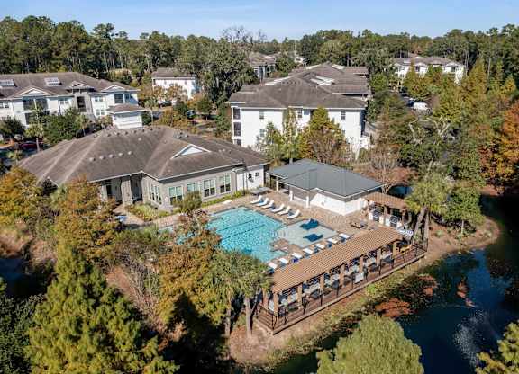 A large white building with a pool in front of it.