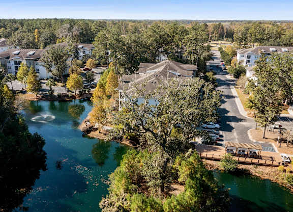 A serene lake surrounded by houses and trees.