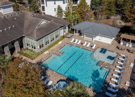 An aerial view of a house with a pool and lounge chairs.