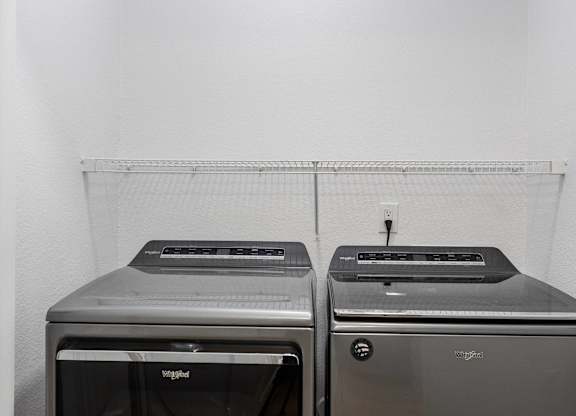 Two toaster ovens are sitting on a shelf.