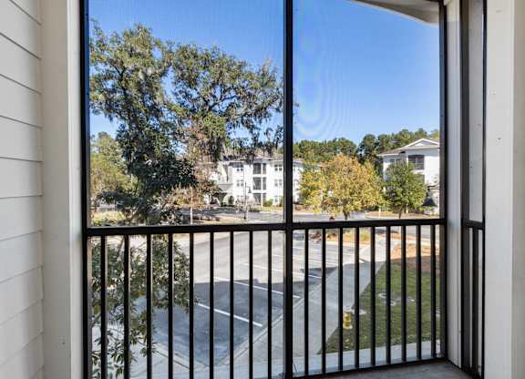 A view from a balcony looking out at a street.