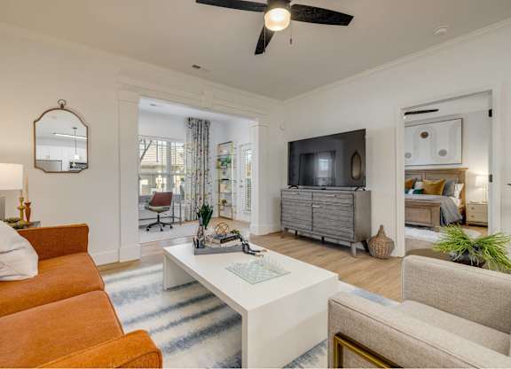 A living room with a white sofa and a white coffee table.