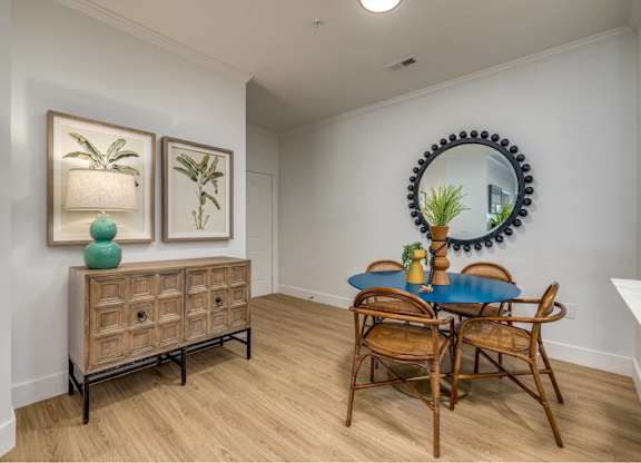 A dining room with a blue table and chairs.