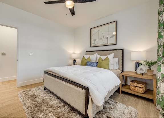 A bedroom with a large bed and a ceiling fan.