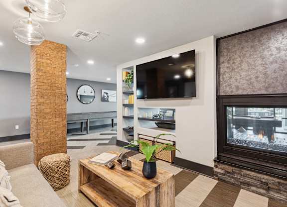 A modern living room with a fireplace and a flat screen TV.