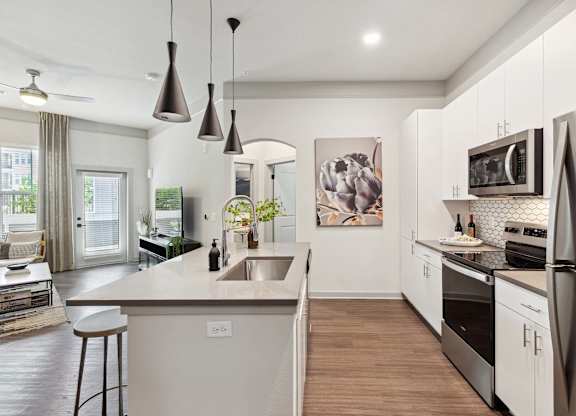 A modern kitchen with a large island and stainless steel appliances.