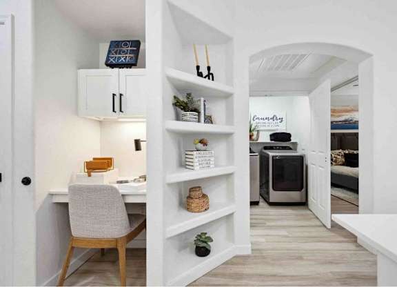 A white room with a desk and a shelf.