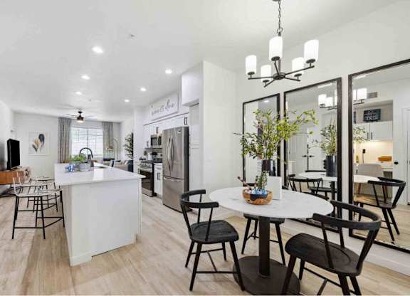 A modern kitchen with a dining table set for four.