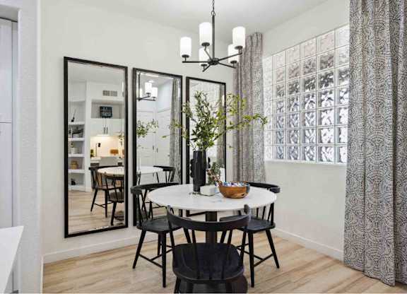A dining room with a round table and chairs.