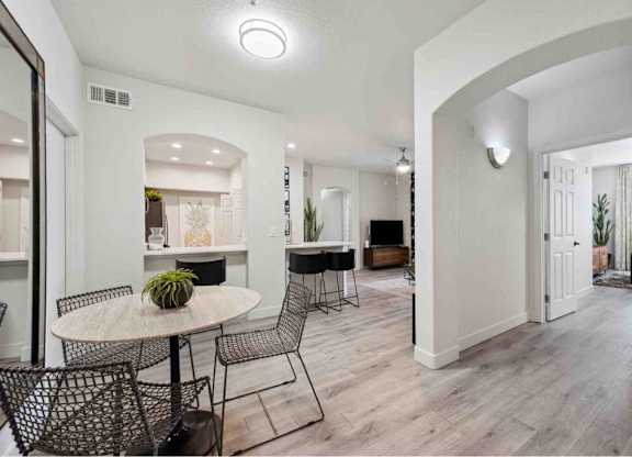A dining area with a round table and chairs.