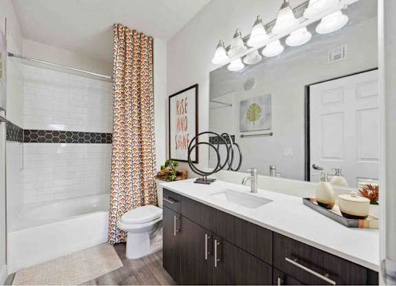 A bathroom with a white tub and a white toilet.