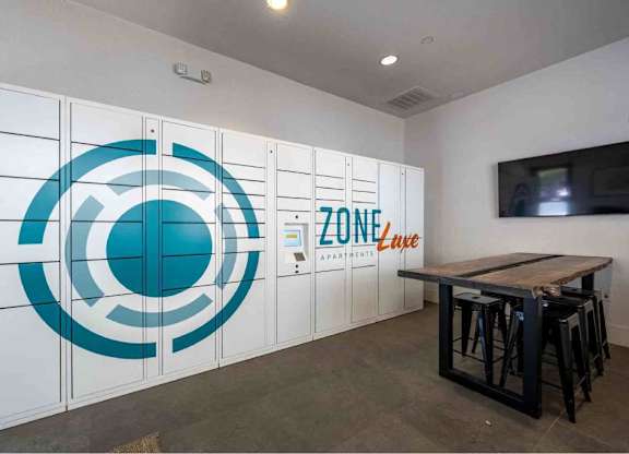 A room with a table and chairs and a wall with a logo and the word ZONE on it.