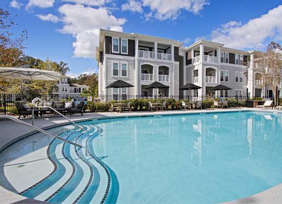 a large swimming pool with an apartment building in the background