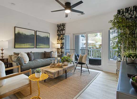 a living room with a couch and a coffee table and a ceiling fan