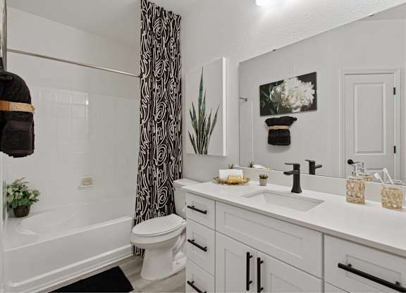 an open bathroom with a shower and a sink and a toilet