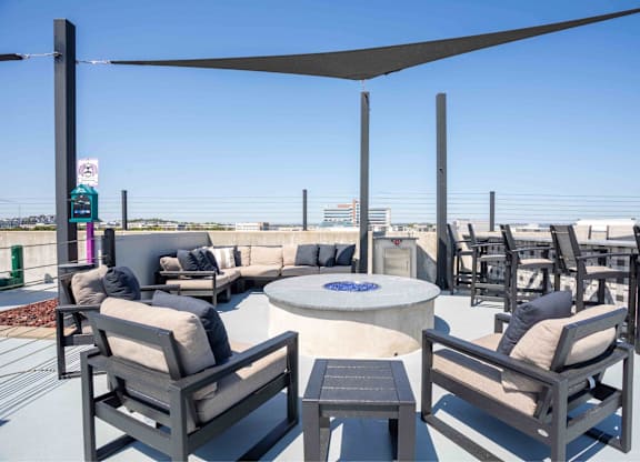 A patio with a table and chairs under a shade sail.