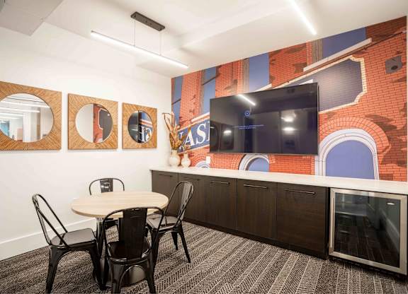 A conference room with a table, chairs and a mural on the wall.