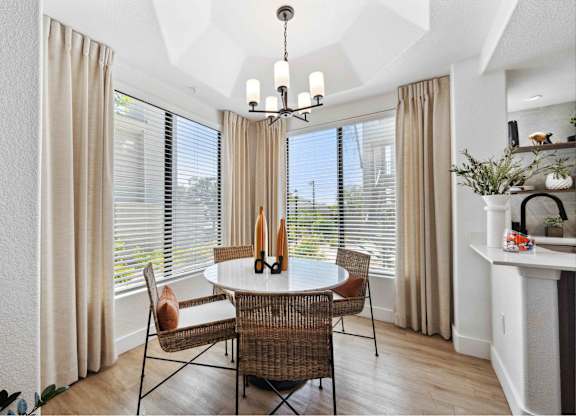 a dining room with large windows and a chandelier