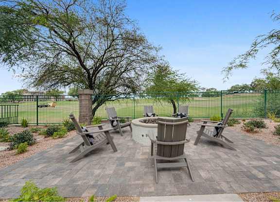 an outdoor patio with a firepit and chairs