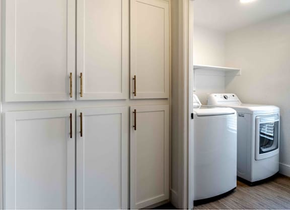 a laundry room with white cabinets and washer and dryer