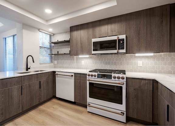 a kitchen with a stove and a sink and a microwave