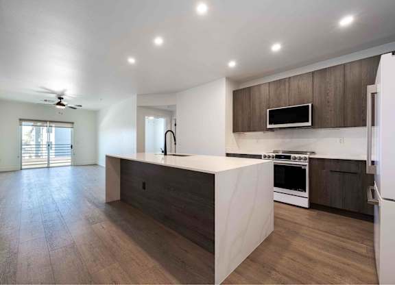 a kitchen with brown cabinets and stainless steel appliances at Slate Scottsdale, lofts for rent Phoenix.