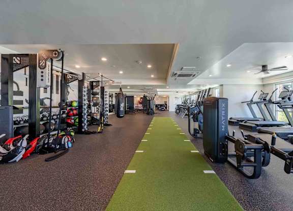a spacious fitness center with cardio machines and weights