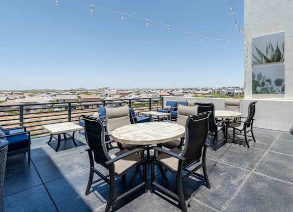 tables and chairs on a rooftop patio with a view of scottsdale arizona