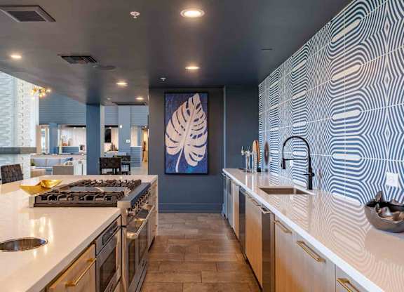 a large kitchen with white countertops and a large painting on the wall