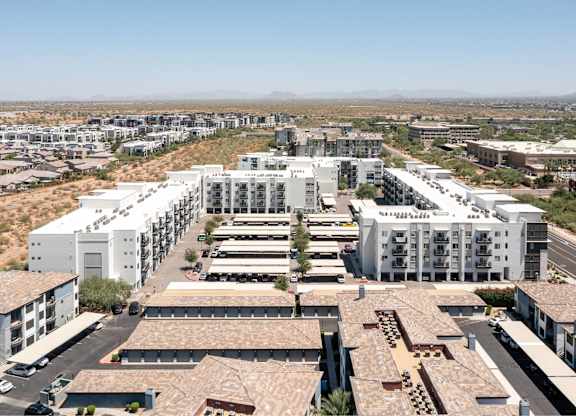 a cityscape of white buildings with a desert in the background