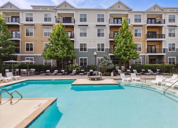 A large swimming pool in front of apartment buildings.