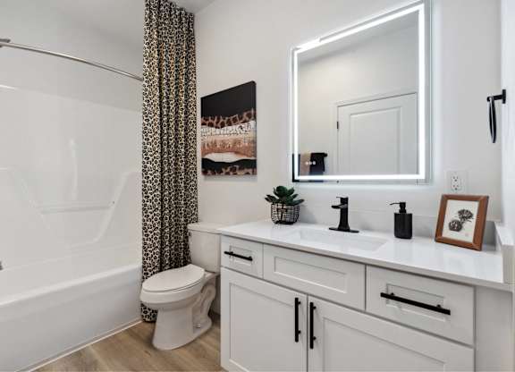 A white bathroom with a toilet, sink, and shower.