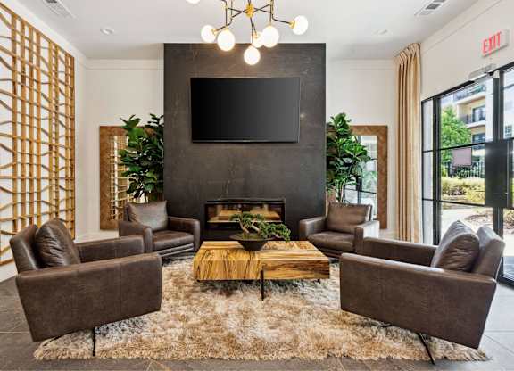 A living room with a fireplace and a flat screen TV mounted on the wall.