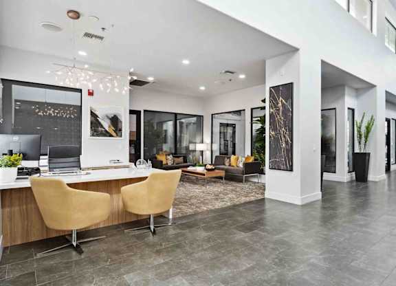 A modern office space with a desk, chairs, and a laptop.