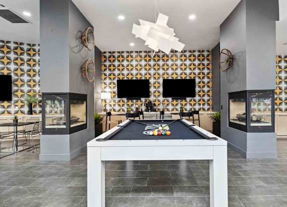 A pool table is in the middle of a room with a black and gold patterned wall.