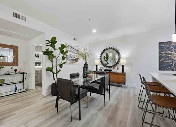 A modern dining room with a wooden table and chairs.