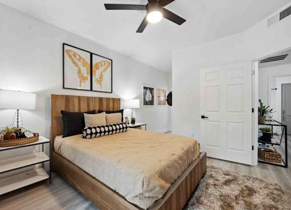 A bedroom with a bed, a ceiling fan, and a rug.