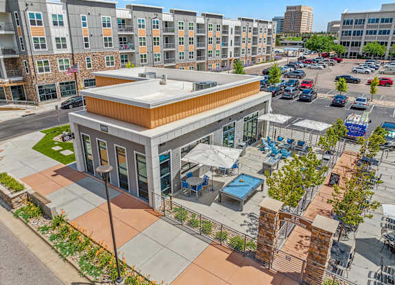 an aerial view of the building with a parking lot in the background
