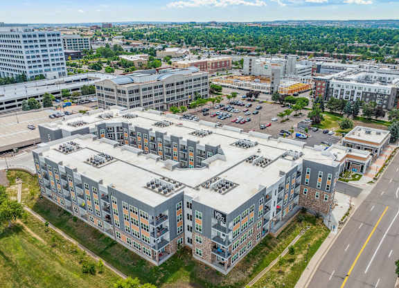 an aerial view of a large building with a parking lot in front of it