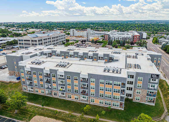 a large building with many windows and a green field in the background