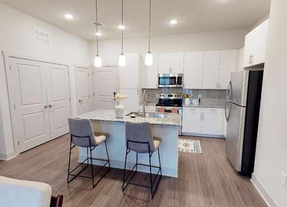 A kitchen with a table and chairs in the middle of the room.